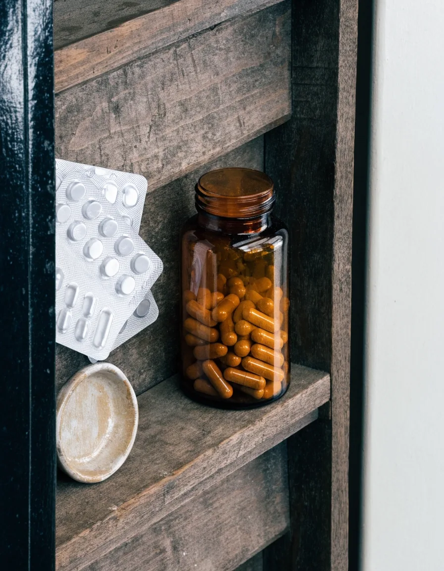 A Jakarta apotek counter in overcast morning light, unbranded amber supplement bottles and tablet blisters arranged along the shelf edge
